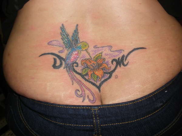 in a lower back bird with a flower tattoo