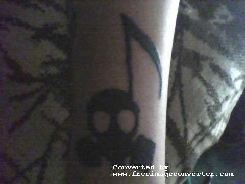 Skull mask music note tattoo
