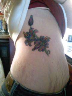 Colorful Flower Rib piece tattoo