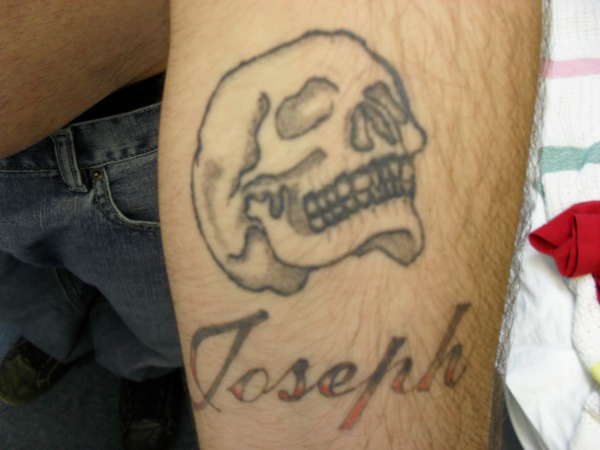 Skull with Biological brothers name underneath tattoo