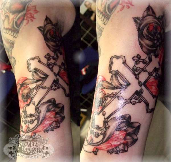 Cross inside arm tattoo