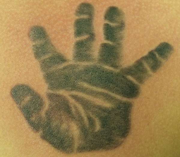 a childs hand tattoo