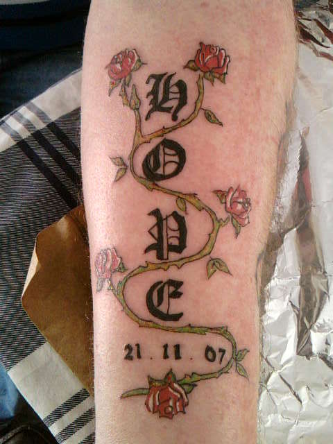 old english with rose forearm tattoo
