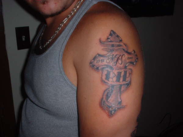 Q's cross tattoo