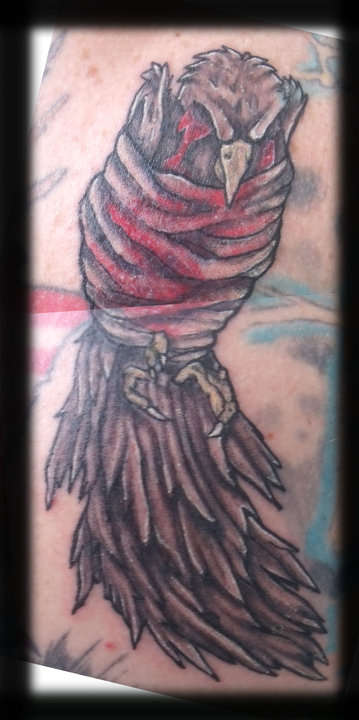 injured bird wrapped tattoo