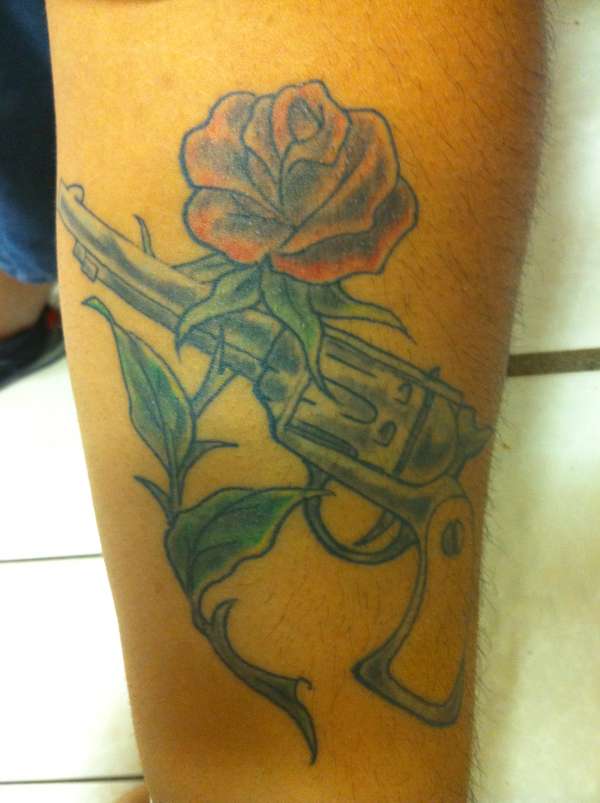 a gun wrapped by a rose tattoo