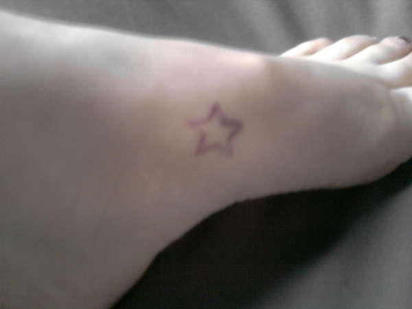Pink star on foot tattoo