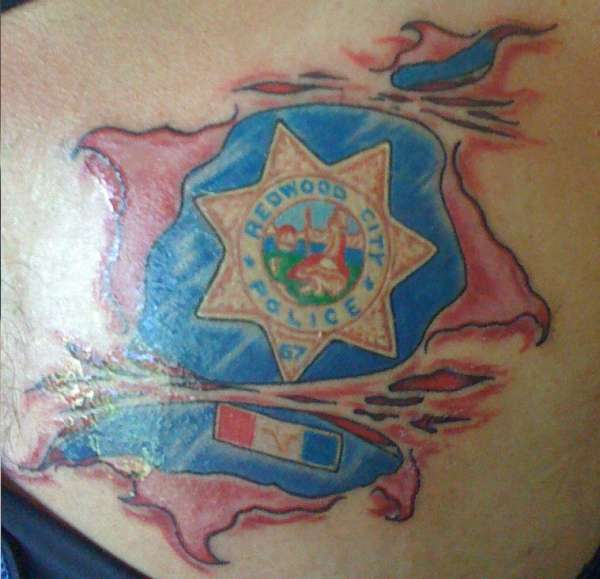 Badge on left chest tattoo