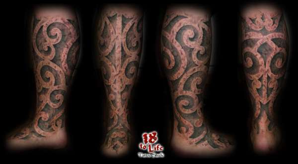 embossed stone tribal leg sleeve tattoo