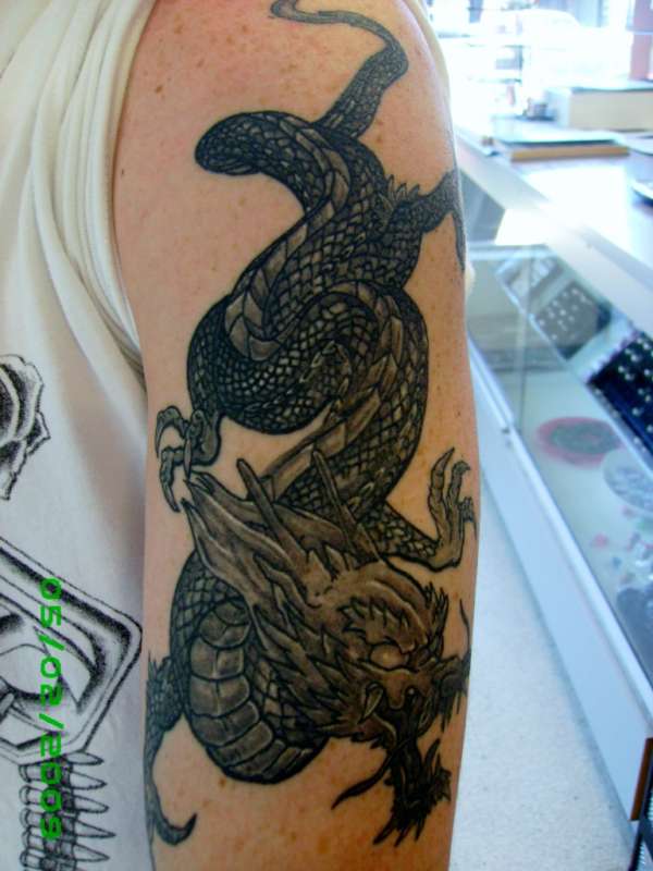 black grey wash dragon arm tattoo