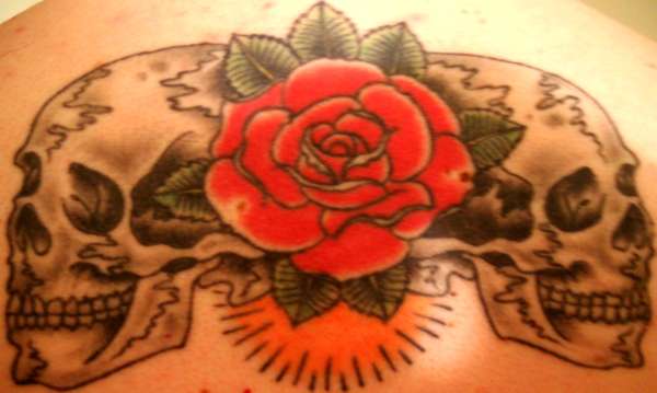 Skulls and rose on back tattoo