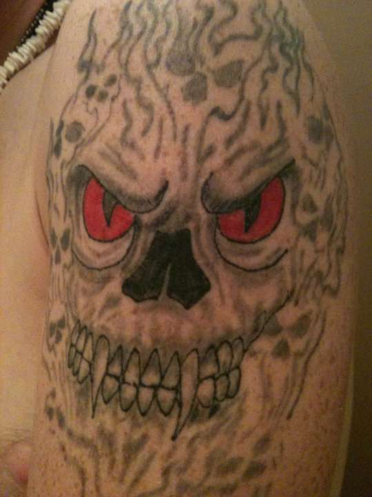 Demon surrounded skull tattoo