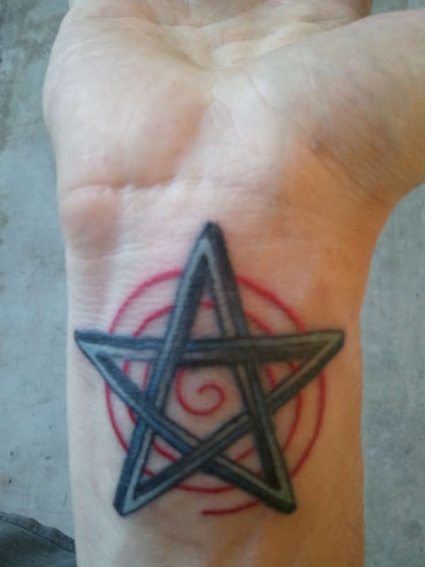 Retouched colored wrist star tattoo