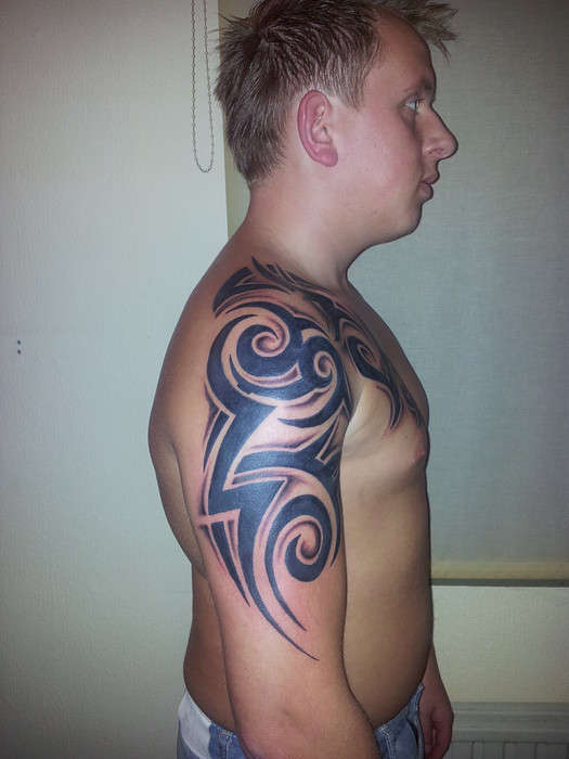 Tribal chest to arm tattoo
