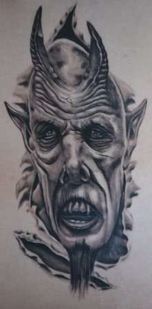Demon ripping out of ribs tattoo