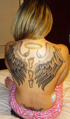 angel wings with horns holding halo tattoo.