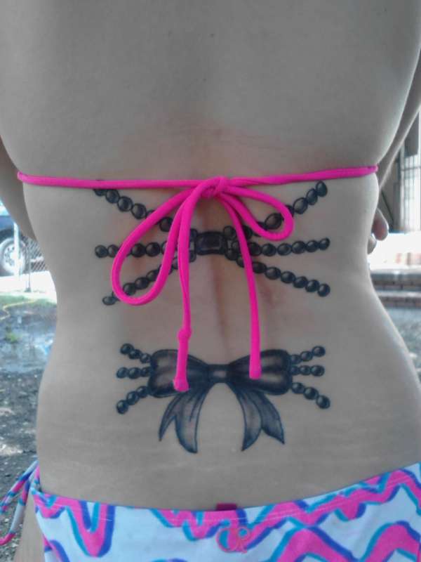 Pearls and ribbon tattoo