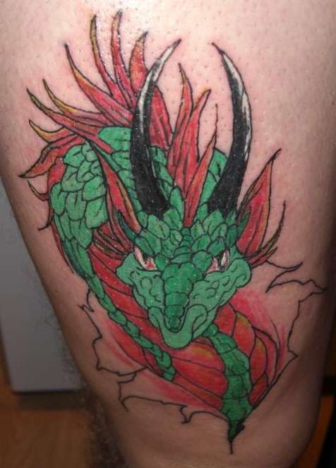 dragons head on thigh tattoo