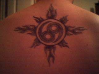 tribal sun with zodiac sign tattoo