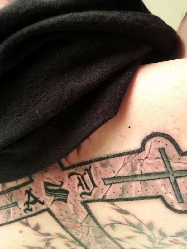 Close-up of stone detail on cross tattoo