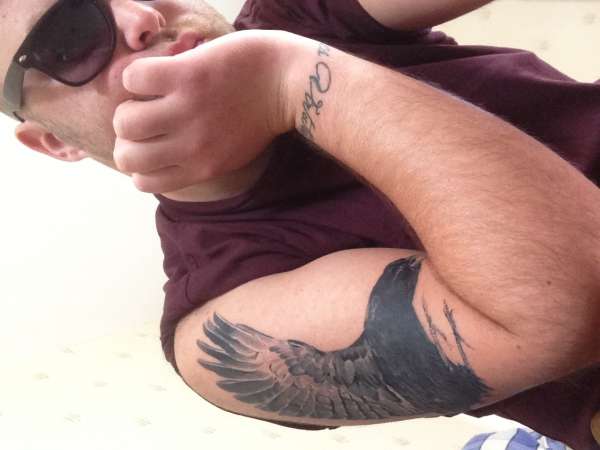 Crow and wrist script tattoo