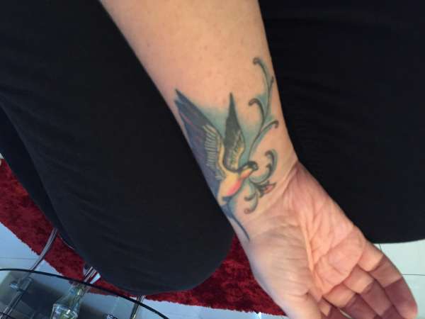 Side of wrist swallow bird tattoo