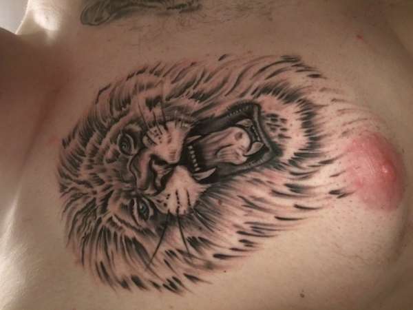 Lion head chest tattoo