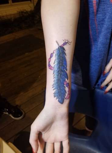 feather cover up tattoo by santa clause!!!!! tattoo