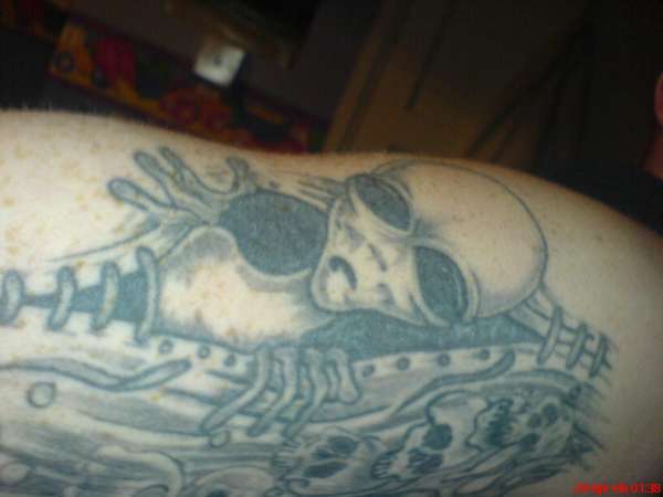 alien comin through skin tattoo