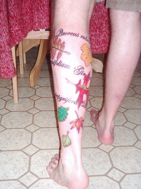 Leaves and writing tattoo