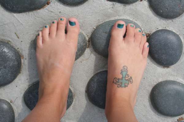 Cross on foot tattoo