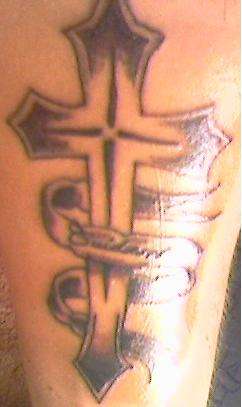 cross tat says "cuidame" meanin take care of me.. tattoo