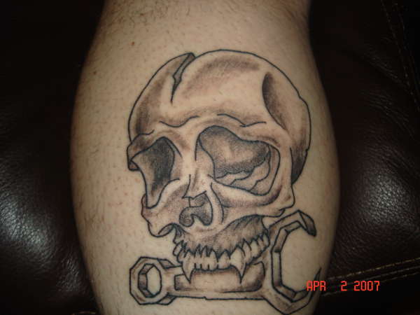Skull biting wrench tattoo