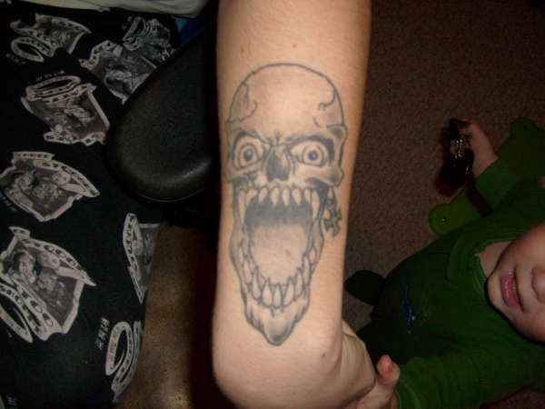 Skull on left  arm tattoo