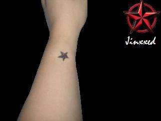 Small star on left wrist tattoo