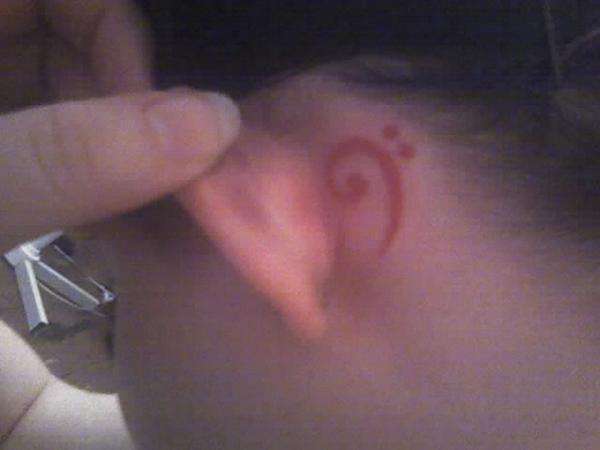 bass clef behind left ear. tattoo