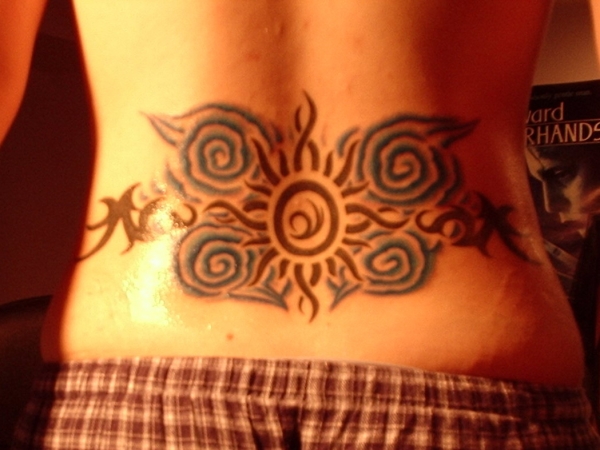 tribal sun with blue swirls tattoo