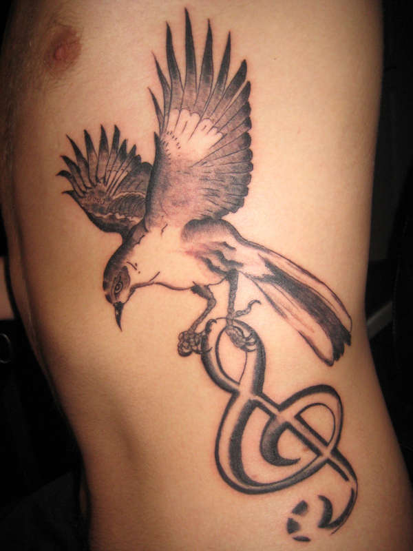 Bird carrying clef tattoo