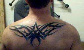 Tribal across shoulders tattoo