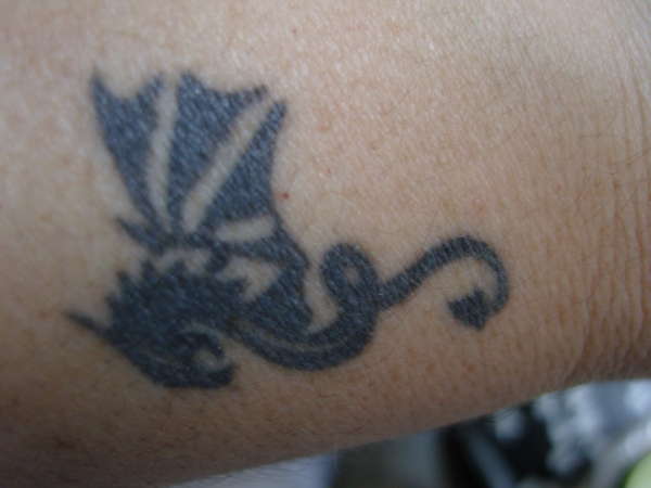 Dragon emblem in left wrist tattoo