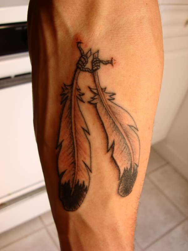 Two feathers joined tattoo