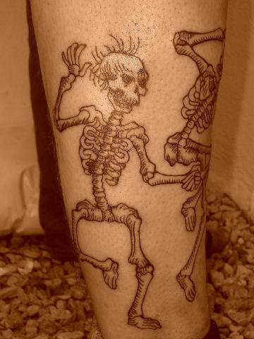 dancing skeletons on johns leg tattoo