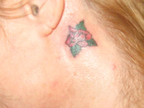 Rose behind left ear tattoo