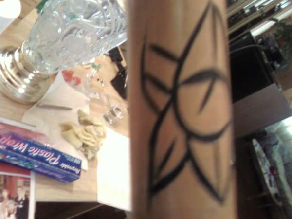 Left side of flower on staf tattoo