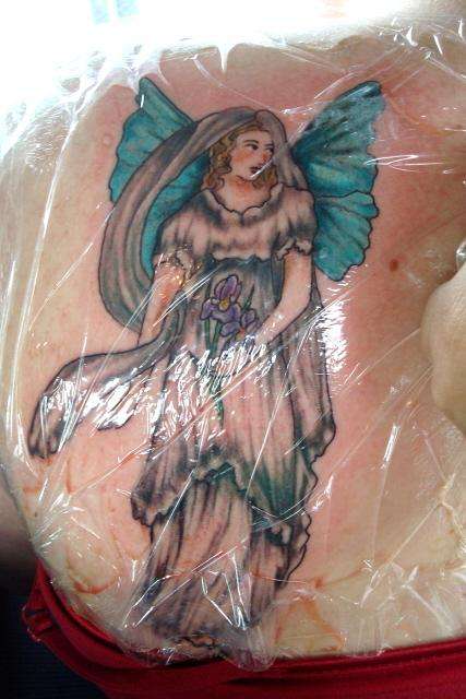 A fairy holding Iris flowers tattoo