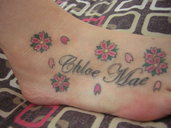 my parteners foot tattoo with our daughters name tattoo