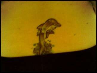 Lower back dolphin tattoo