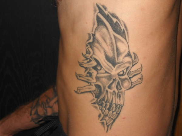 skull rip n out of skin tattoo