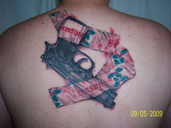 Gun taped to back with xmas tape tattoo