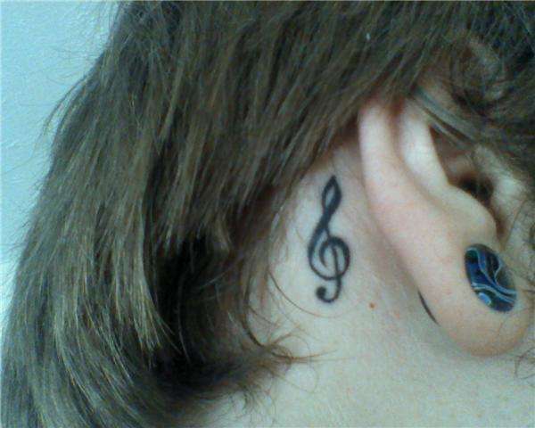 Treble clef behind ear tattoo